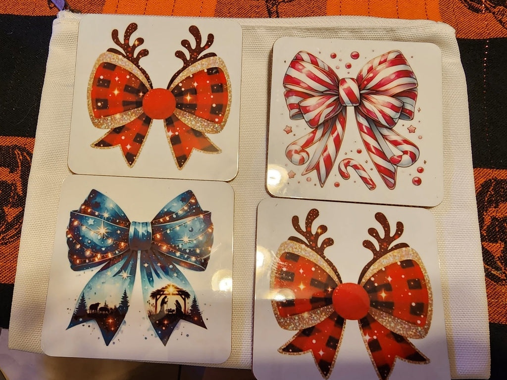 Four square decorative coasters with rounded corners. Each coaster features a festive bow design: one blue galaxy bow, one red plaid bow with reindeer antlers, one matching red plaid bow, and one red-and-white candy cane bow.