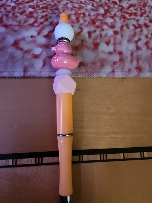 Pink rubber ducky pen on an orange base
