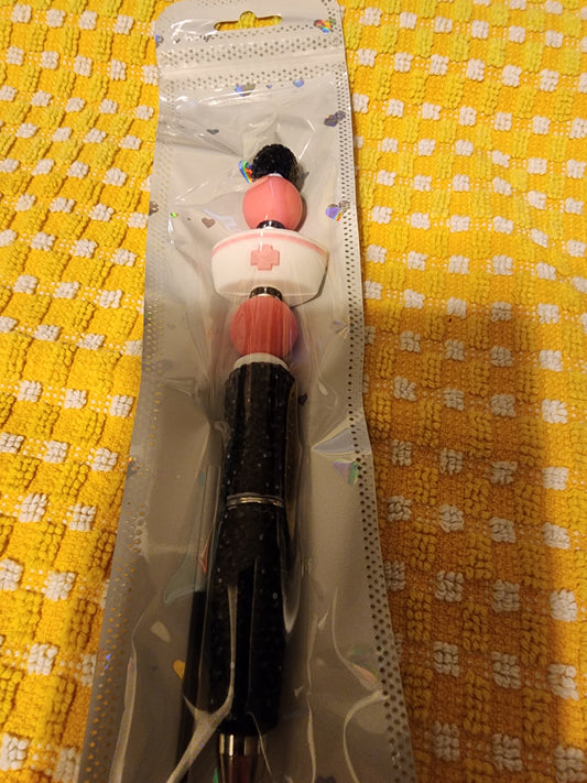 Sparkly black pen with pink and white medical hat