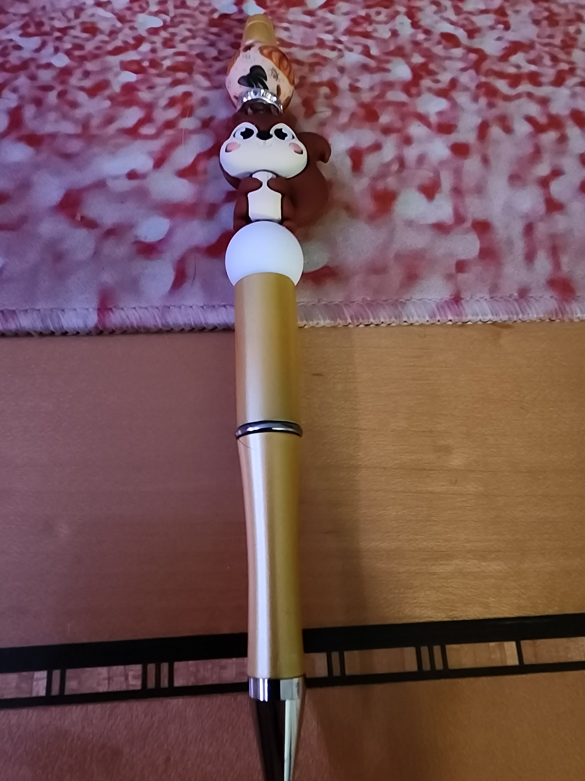 Squirrel pen with a pumpkin bead on a golden matte pen