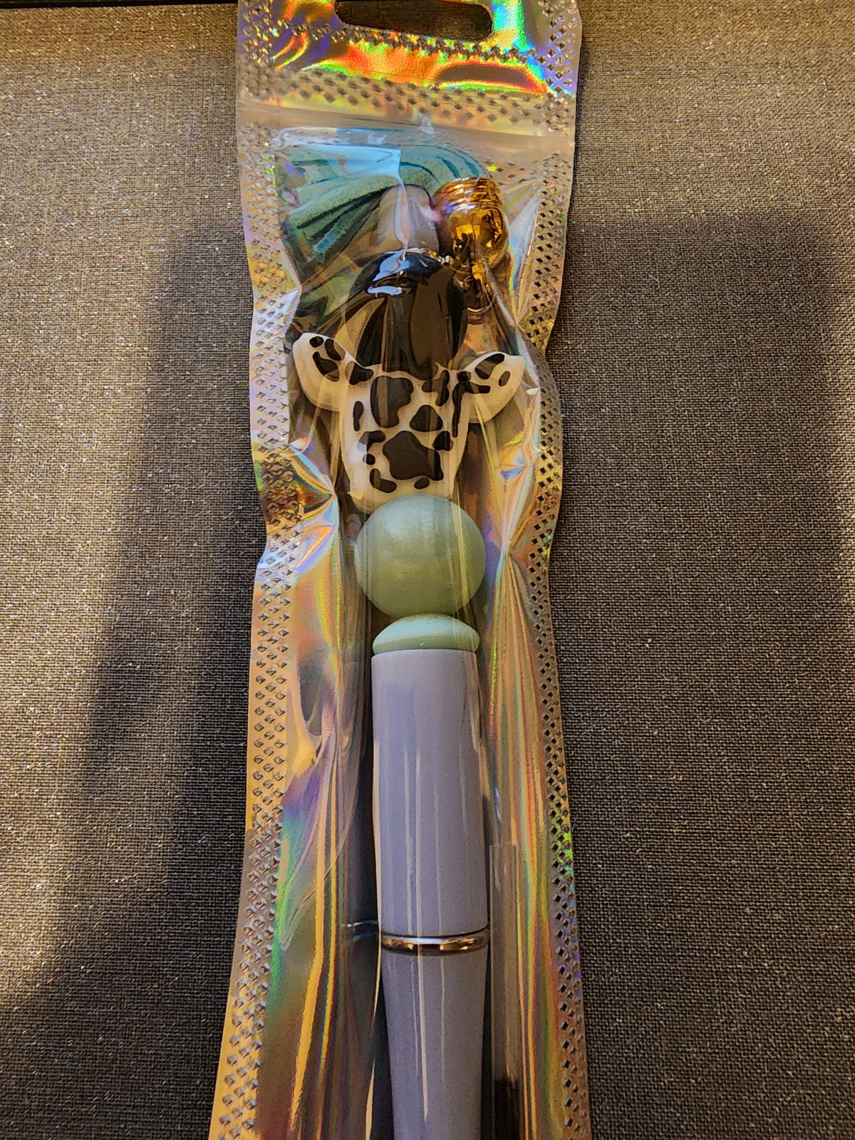 Black and white cow print head with blue tassel pen